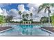 Large community swimming pool featuring lounge chairs and a gazebo, all surrounded by lush landscaping and palm trees at 621 Lost Grove Cir, Winter Garden, FL 34787