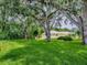 Spacious backyard with mature trees offering shade and a well-maintained lawn at 627 Timbercrest Dr, Leesburg, FL 34748