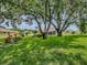 Lush backyard with mature trees providing shade and privacy for the homes in the distance at 627 Timbercrest Dr, Leesburg, FL 34748