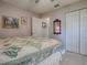 Comfortable bedroom with a decorative quilt, white closet doors, and soft lighting at 627 Timbercrest Dr, Leesburg, FL 34748