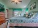 Bright bedroom featuring a large bed, ceiling fan, and multiple ocean-themed paintings at 627 Timbercrest Dr, Leesburg, FL 34748