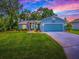 Charming single-story home with a well-manicured lawn, blue siding, and an attached two-car garage at 627 Timbercrest Dr, Leesburg, FL 34748