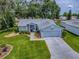 Charming single-story home with well-manicured lawn, inviting walkway, and attached two-car garage at 627 Timbercrest Dr, Leesburg, FL 34748