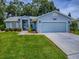 Charming home exterior with a well-manicured lawn, a neatly paved driveway, and a cozy entryway at 627 Timbercrest Dr, Leesburg, FL 34748