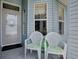 Close up of an inviting front porch with seating and lovely light blue siding and trim at 627 Timbercrest Dr, Leesburg, FL 34748