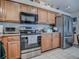 Bright kitchen featuring stainless appliances, granite countertops, and wooden cabinets at 627 Timbercrest Dr, Leesburg, FL 34748