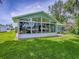 Exterior of the sunroom featuring large glass windows and access to the backyard at 627 Timbercrest Dr, Leesburg, FL 34748