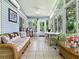 Inviting sunroom with tile floors, a comfortable wicker sofa, and views of the beautiful outdoor scenery at 627 Timbercrest Dr, Leesburg, FL 34748