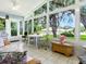 Bright sunroom with large windows, tile floors, and comfortable seating overlooking the lush backyard at 627 Timbercrest Dr, Leesburg, FL 34748