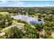 Aerial view capturing a home by a lake, surrounded by verdant trees, under a clear blue sky at 628 Drew Ave, Clermont, FL 34711