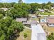 Aerial view of a home with an in-ground pool and a detached in-ground trampoline surrounded by mature trees at 628 Drew Ave, Clermont, FL 34711