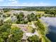 Elevated perspective capturing a home by the lakeside, harmonizing with lush trees, under a serene blue sky at 628 Drew Ave, Clermont, FL 34711