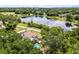 Aerial of a home with a pool near a lake in a lush, green neighborhood under a bright, sunny sky at 628 Drew Ave, Clermont, FL 34711