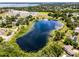 Picturesque aerial view of a serene pond surrounded by lush trees and houses at 628 Drew Ave, Clermont, FL 34711