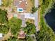 Stunning aerial view of a lakeside property with mature trees and a lush landscaped yard at 628 Drew Ave, Clermont, FL 34711