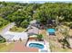 An aerial view of a home with an in-ground pool, large backyard and a long concrete driveway at 628 Drew Ave, Clermont, FL 34711