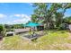 Beautiful backyard featuring a blue shade over a seating area with tranquil lake views at 628 Drew Ave, Clermont, FL 34711