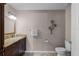 Well-lit bathroom with granite countertops, dark wood cabinets and a decorative flower on the wall at 628 Drew Ave, Clermont, FL 34711