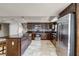 Modern kitchen featuring a large island, stainless steel appliances, tile floors and dark cabinets at 628 Drew Ave, Clermont, FL 34711