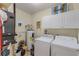 Functional laundry room with white appliances and overhead storage cabinets at 628 Drew Ave, Clermont, FL 34711