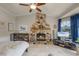 Inviting living room with a stone fireplace, tile flooring, and bright, natural light at 628 Drew Ave, Clermont, FL 34711