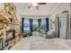 Cozy living room features a stone fireplace, tile flooring, and bay windows with natural light at 628 Drew Ave, Clermont, FL 34711