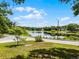 A picturesque view of a tranquil pond from a grassy lawn next to a paved street at 628 Drew Ave, Clermont, FL 34711