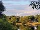Picturesque water view reflecting the clear blue sky with trees and a distant white tower at 628 Drew Ave, Clermont, FL 34711