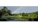 Scenic water view featuring a vibrant rainbow over lush green trees and a serene lake at 628 Drew Ave, Clermont, FL 34711