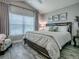 This cozy bedroom features wood-look floors, a large window with blinds, and lots of natural light at 6295 Danielson Loop, The Villages, FL 32163