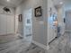 View through doorway to a kitchen with white cabinets and stainless appliances, and a hall leading to a bathroom at 6295 Danielson Loop, The Villages, FL 32163