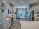 A modern kitchen showcases white cabinets, a mosaic backsplash, stainless steel appliances, and wood-look floors at 6295 Danielson Loop, The Villages, FL 32163