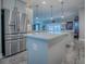 A modern kitchen with stainless appliances, a center island with white countertops, and white cabinets at 6295 Danielson Loop, The Villages, FL 32163