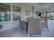 Outdoor lanai with wicker chairs, a dining table, and views of the lush backyard at 6295 Danielson Loop, The Villages, FL 32163