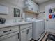 Well-organized laundry room with modern washer, dryer, sink, and ample cabinet space at 6295 Danielson Loop, The Villages, FL 32163