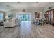 Spacious living room with sliding glass doors to the lanai, wood-look floors, and neutral decor at 6295 Danielson Loop, The Villages, FL 32163