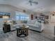 Bright living room featuring wood-look floors, stylish furniture, and an adjacent dining area at 6295 Danielson Loop, The Villages, FL 32163