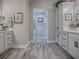 Bright main bathroom with double vanity, lots of storage, framed mirror, and stylish wood-look tile flooring at 6295 Danielson Loop, The Villages, FL 32163