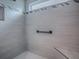 Bright shower with white tile and decorative accent stripe, niche, corner bench, and contrasting black hardware at 6295 Danielson Loop, The Villages, FL 32163