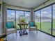 Bright sunroom with wicker chairs, accent table, and large windows overlooking the backyard at 6295 Danielson Loop, The Villages, FL 32163