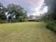 Expansive backyard featuring mature trees and ample space for outdoor activities and landscaping at 6616 Tuscawilla Dr, Leesburg, FL 34748