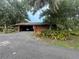 Charming home featuring an open carport, mature landscaping, and a convenient circular driveway at 6616 Tuscawilla Dr, Leesburg, FL 34748