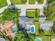 Aerial view of a home featuring a backyard pool, gray roof, green lawn, and long driveway at 6829 Bittersweet Ln, Orlando, FL 32819