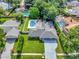 Aerial view of property with a sparkling pool, lush lawn, and driveway leading to a well-maintained home at 6829 Bittersweet Ln, Orlando, FL 32819
