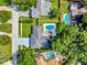 Aerial view of a home with a backyard pool, green lawn, and long driveway at 6829 Bittersweet Ln, Orlando, FL 32819