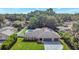 Aerial view of the single-story home with a well manicured lawn, lush landscaping and inviting backyard pool at 6829 Bittersweet Ln, Orlando, FL 32819
