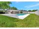 Expansive backyard featuring a sparkling in-ground pool, covered patio, and lush landscaping at 6829 Bittersweet Ln, Orlando, FL 32819
