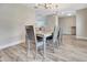 Formal dining room with modern chandelier, wood floors, and a large wooden table at 6829 Bittersweet Ln, Orlando, FL 32819