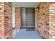 Inviting front entrance featuring a decorative front door with brick surround and outdoor lighting at 6829 Bittersweet Ln, Orlando, FL 32819