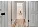 Hallway with doors leading to carpeted bedrooms, featuring attractive laminate flooring at 6829 Bittersweet Ln, Orlando, FL 32819